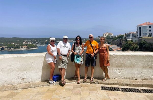 Grupa turystów na punkcie widokowym w Mahón – panorama portu i malownicze krajobrazy Minorki.