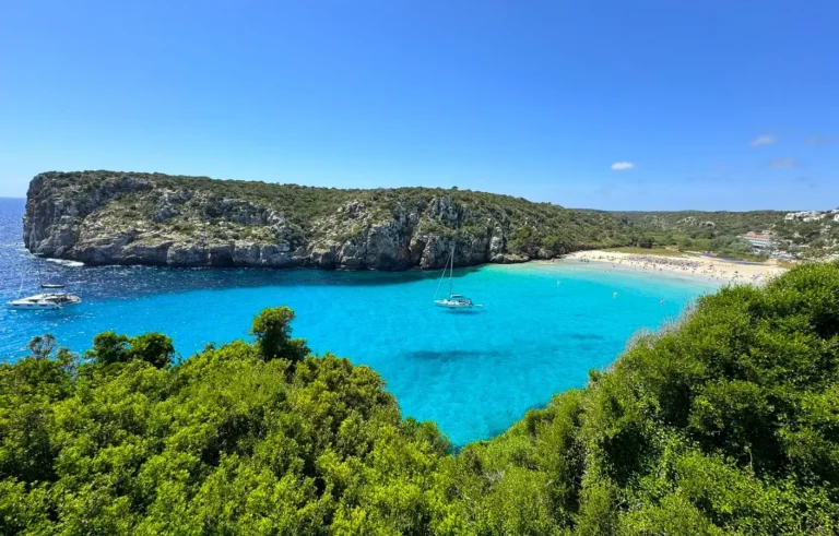 Plaża Binigaus z turkusową wodą i jachtami, Minorka