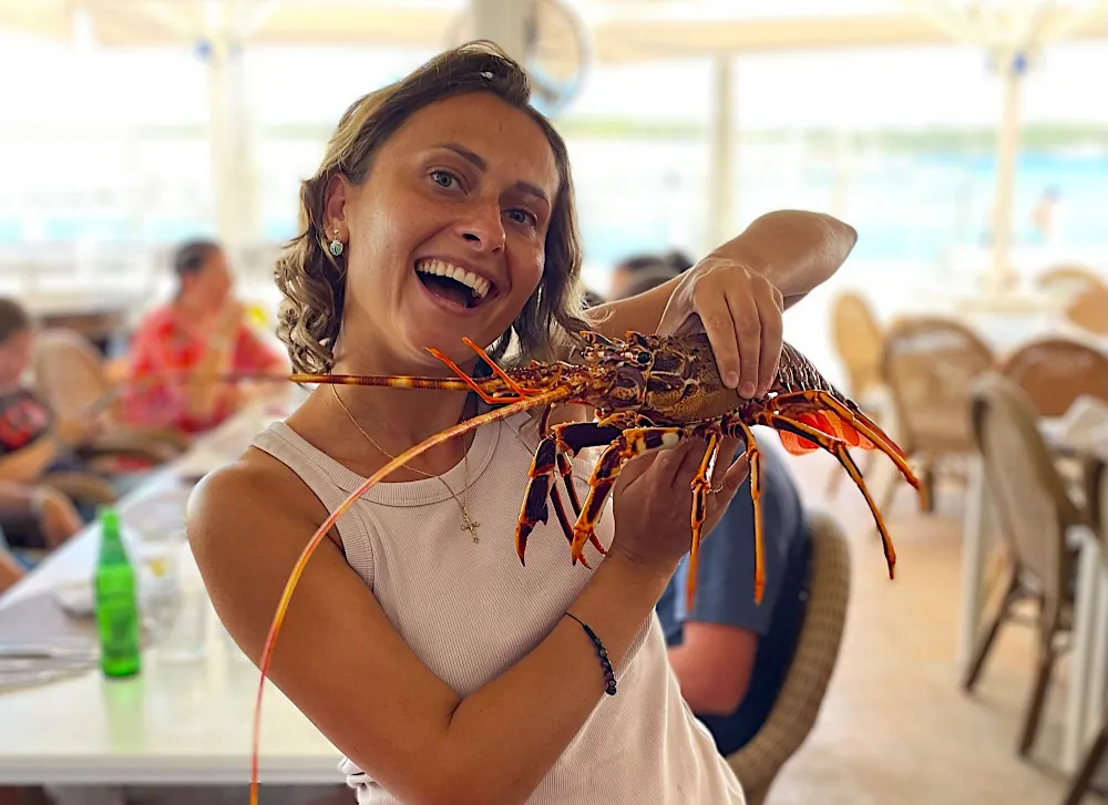 Kobieta trzymająca langustę w restauracji na Minorce