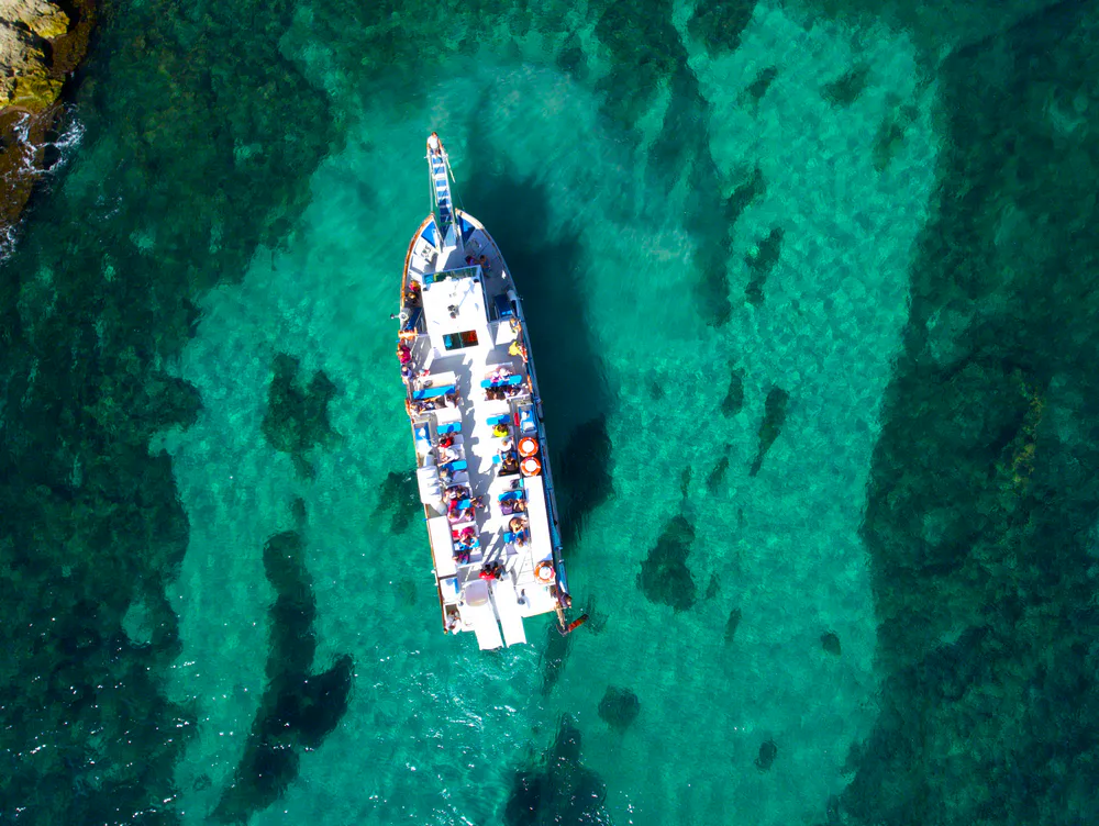 Łódź wycieczkowa na turkusowej wodzie u wybrzeży Minorki
